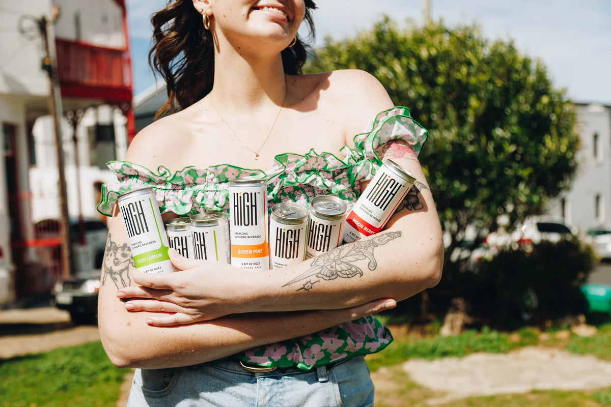 A woman carrying an armful of the three HIGH flavour variants